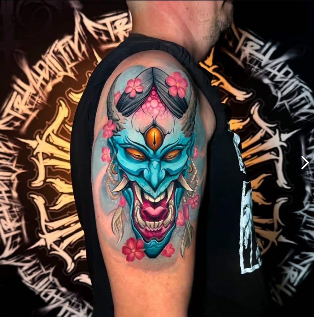 Нео-традиционная цветная тату на плече: маска и сакура. Работа студии Ink Masters.