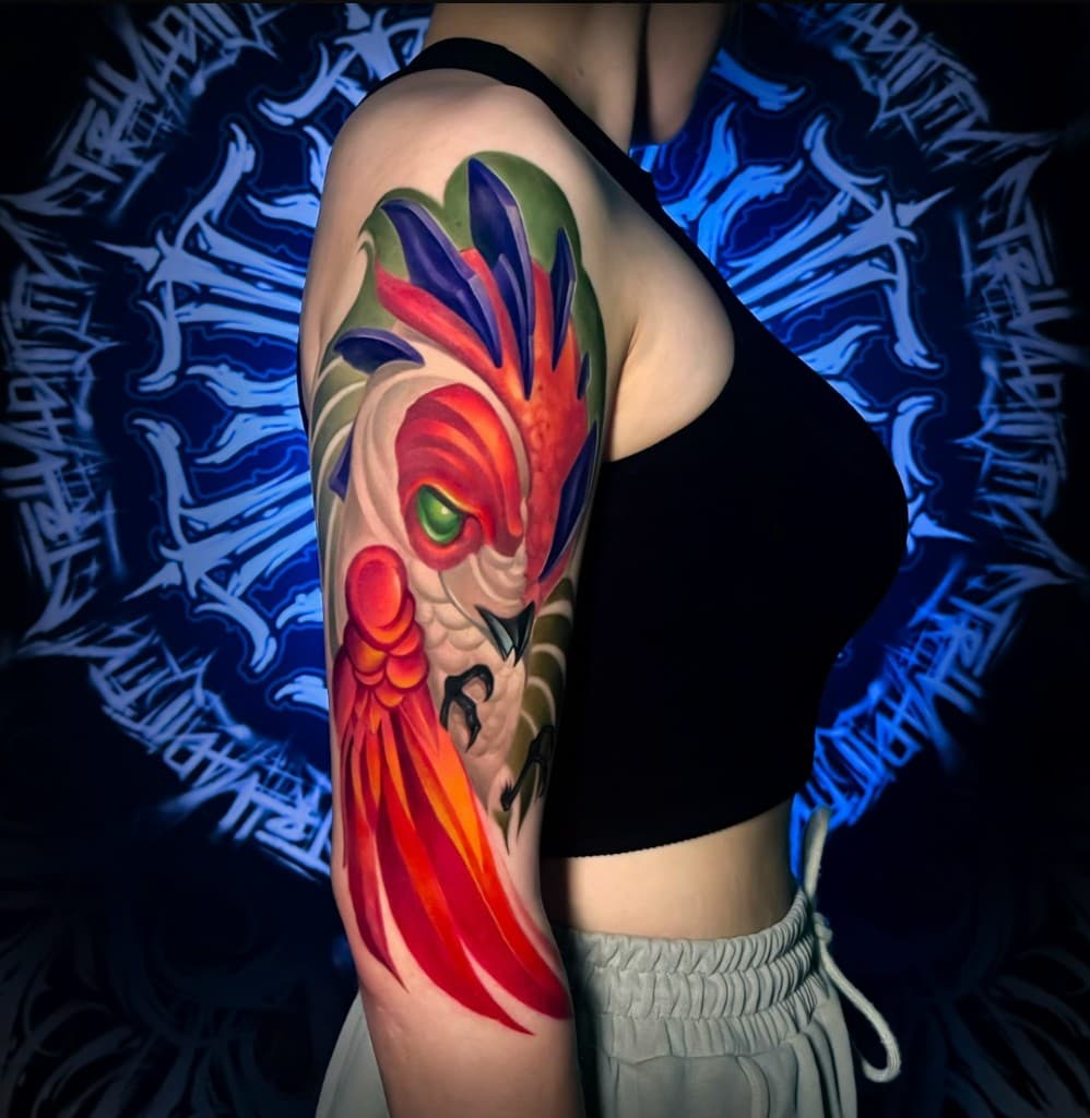 Цветная тату на плече: птица, яркая палитра. Работа студии Ink Masters.